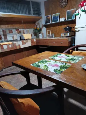 a kitchen with a wooden table with a table cloth on it at Edificio El Barrio Vertical in San José