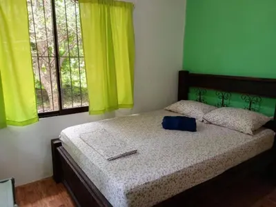 a bedroom with a bed with a blue bag on it at La casita JSL in Ramos