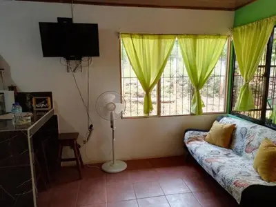 a living room with a couch and two windows at La casita JSL in Ramos