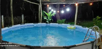 a large swimming pool in a backyard at night at La casita JSL in Ramos
