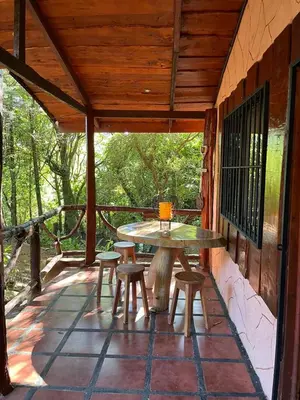 a patio with a table and stools on a porch at Cabañas Lunas del Poás in Bajos Tigre