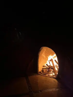 a fireplace with a fire in it in the dark at Cabañas Lunas del Poás in Bajos Tigre