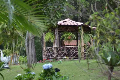 a gazebo in the middle of a garden at Cabañas Lunas del Poás in Bajos Tigre