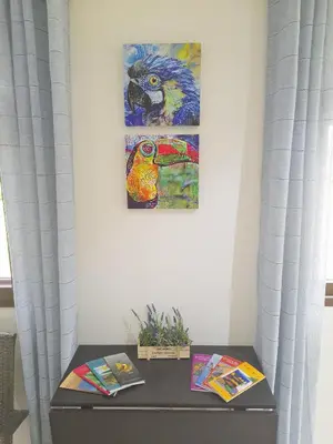 a table with two books and paintings on a wall at Lakeview Arenal Suite - 2025-2026 Traveller Award Winners in Tronadora