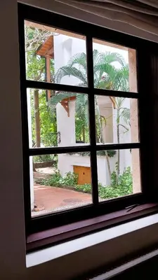 a window with a view of a courtyard with palm trees at Las Catalinas - Studio Cazenovia centrally located, short walk to beach in Playa Danta