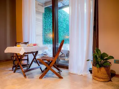 a table and chairs in a room with a window at ARjAU Boutique Hotel - Adults Only in Santa Teresa Beach