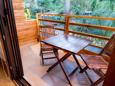 a wooden table and a chair on a balcony at ARjAU Boutique Hotel - Adults Only in Santa Teresa Beach