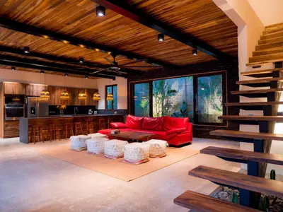 a living room with a red couch and a kitchen at ARjAU Boutique Hotel - Adults Only in Santa Teresa Beach