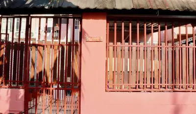 a pink building with metal bars on the door at Apartamentos Estudio Junto al Mar in Puntarenas