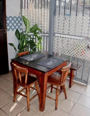 a wooden table with two chairs and a table with a plant at Apartamentos Estudio Junto al Mar in Puntarenas