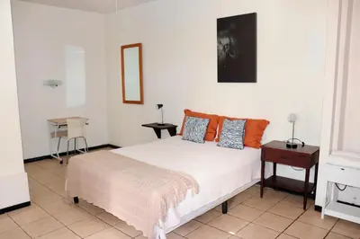 a bedroom with a bed and a table at Apartamentos Estudio Junto al Mar in Puntarenas