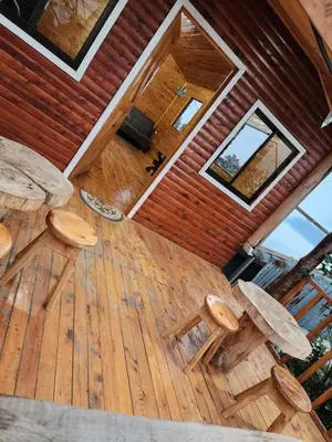 a room with wooden floors and chairs and windows at Cabaña el Faisán, Jardín de Dota in Jardín