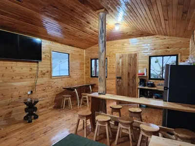 a log cabin with a bar and stools at Cabaña el Faisán, Jardín de Dota in Jardín