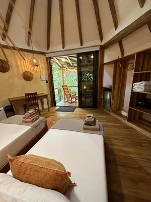 a room with two beds and a living room at Tierra Encantada Wellness Center in Nosara