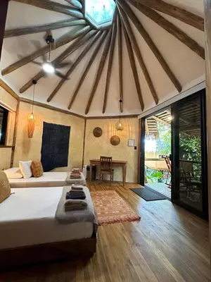a bedroom with a bed and a table in a room at Tierra Encantada Wellness Center in Nosara