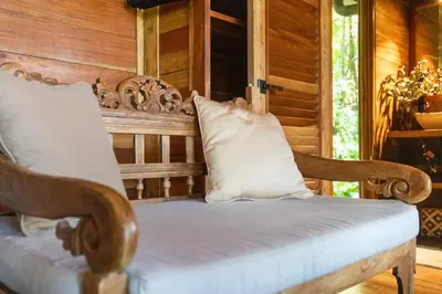a wooden chair with a pillow on a porch at Tierra Encantada Wellness Center in Nosara