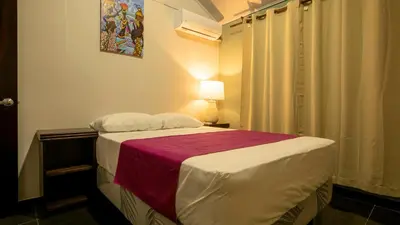 a bedroom with a bed with a red and white blanket at Anthurium house in Fortuna