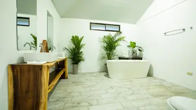 a bathroom with two sinks and a tub and plants at Anthurium house in Fortuna