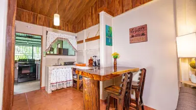 a kitchen with a wooden table in a room at Arenal Dream Cottage in Fortuna
