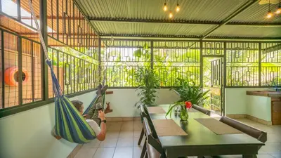 a person in a hammock in a restaurant at Arenal Dream Cottage in Fortuna