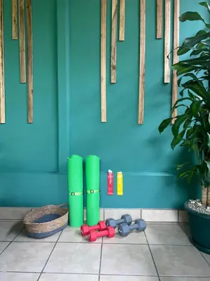 a room with a blue wall and green cylinders on the floor at Arenal Dream Cottage in Fortuna