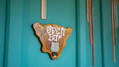 a wooden dog sign on a blue door at Arenal Dream Cottage in Fortuna