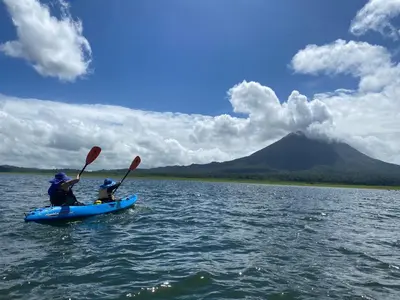 two people in a kayak on a lake with a mountain at Arenal Dream Cottage in Fortuna