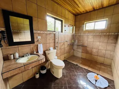a bathroom with a toilet and a sink and a mirror at TucanTico Lodge ~ Casa # 3 in Monteverde Costa Rica