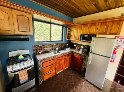 a kitchen with a white refrigerator and a stove at TucanTico Lodge ~ Casa # 3 in Monteverde Costa Rica