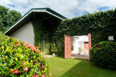 a house with a red door in a yard at Hotel Por Que No? in Uvita