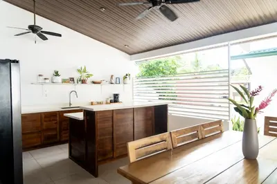 a kitchen with wooden cabinets and a large window at Hotel Por Que No? in Uvita