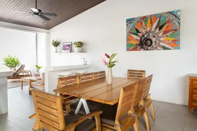 a dining room with a wooden table and chairs at Hotel Por Que No? in Uvita