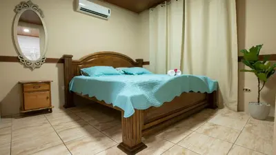 a bedroom with a bed with blue sheets and a mirror at Villa Buganvilia Fortuna Centro in Fortuna