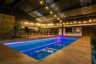 an indoor swimming pool with lights on the ceiling at Villa Buganvilia Fortuna Centro in Fortuna