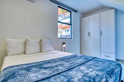 a bedroom with a bed and a window at Muna Tamarindo in Tamarindo