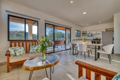 a living room with a couch and a table at Muna Tamarindo in Tamarindo