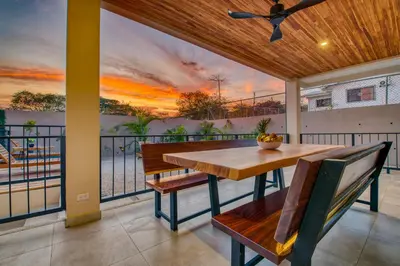 a dining room with a table and chairs on a balcony at Muna Tamarindo in Tamarindo