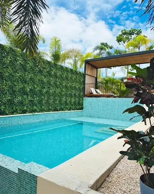 a swimming pool in front of a house at Muna Tamarindo in Tamarindo