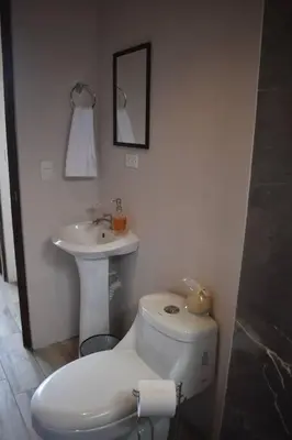 a bathroom with a toilet and a sink at Casa Luna, espacio moderno y acogedor in Liberia