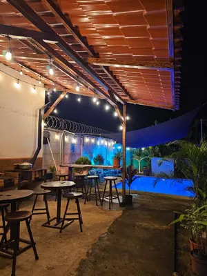 a patio with tables and chairs and an umbrella at Casa Luna, espacio moderno y acogedor in Liberia