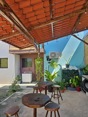 a patio with tables and stools under a pergola at Casa Luna, espacio moderno y acogedor in Liberia