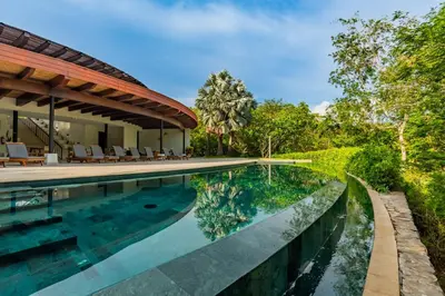an image of a swimming pool next to a house at Modern 3BR Condo with Partial Ocean View - Carao - Reserva Conchal Golf Resort in Playa Conchal