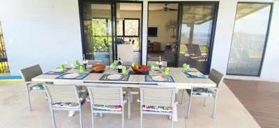 a dining room table with white chairs and a white table at Incroyable Villa HermoSamara in Sámara