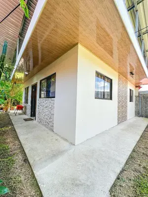 a building with two white doors on the side of it at La Fortuna Donwtown Dreams in Fortuna