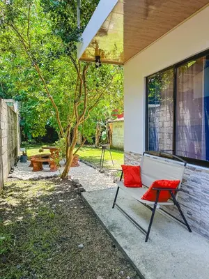 a porch with a bench and a tree at La Fortuna Donwtown Dreams in Fortuna