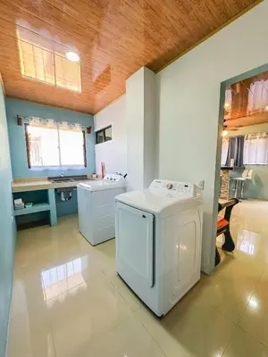 a laundry room with a washer and dryer and a desk at La Fortuna Donwtown Dreams in Fortuna