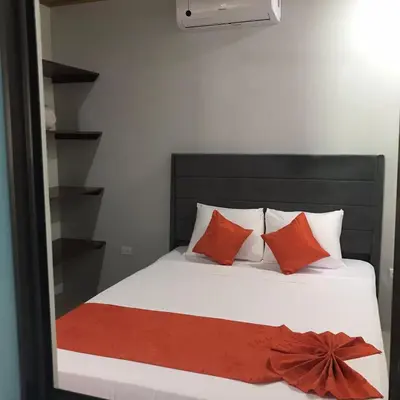 a bedroom with a bed with red pillows and a mirror at La Fortuna Donwtown Dreams in Fortuna