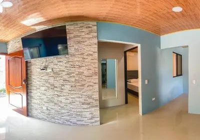 a room with a brick wall with a mirror at La Fortuna Donwtown Dreams in Fortuna