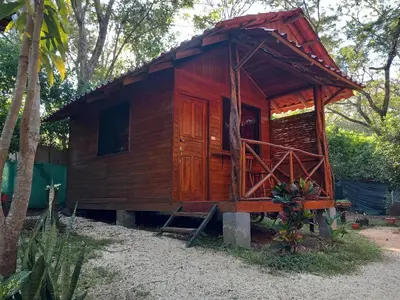 a small wooden house with a red roof at Aura Bungalow 2 in Tamarindo