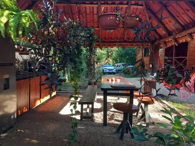 a table and a bench under a building with plants at Aura Bungalow 2 in Tamarindo